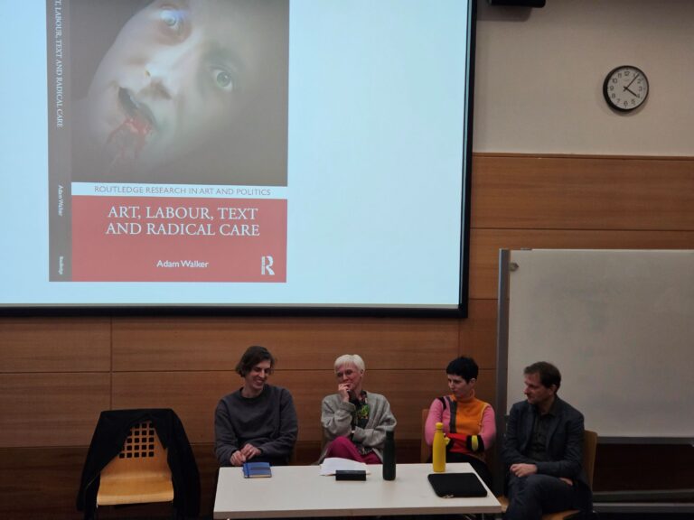 Panel pf 4 panel speakers in front of a projection of a black and red book cover